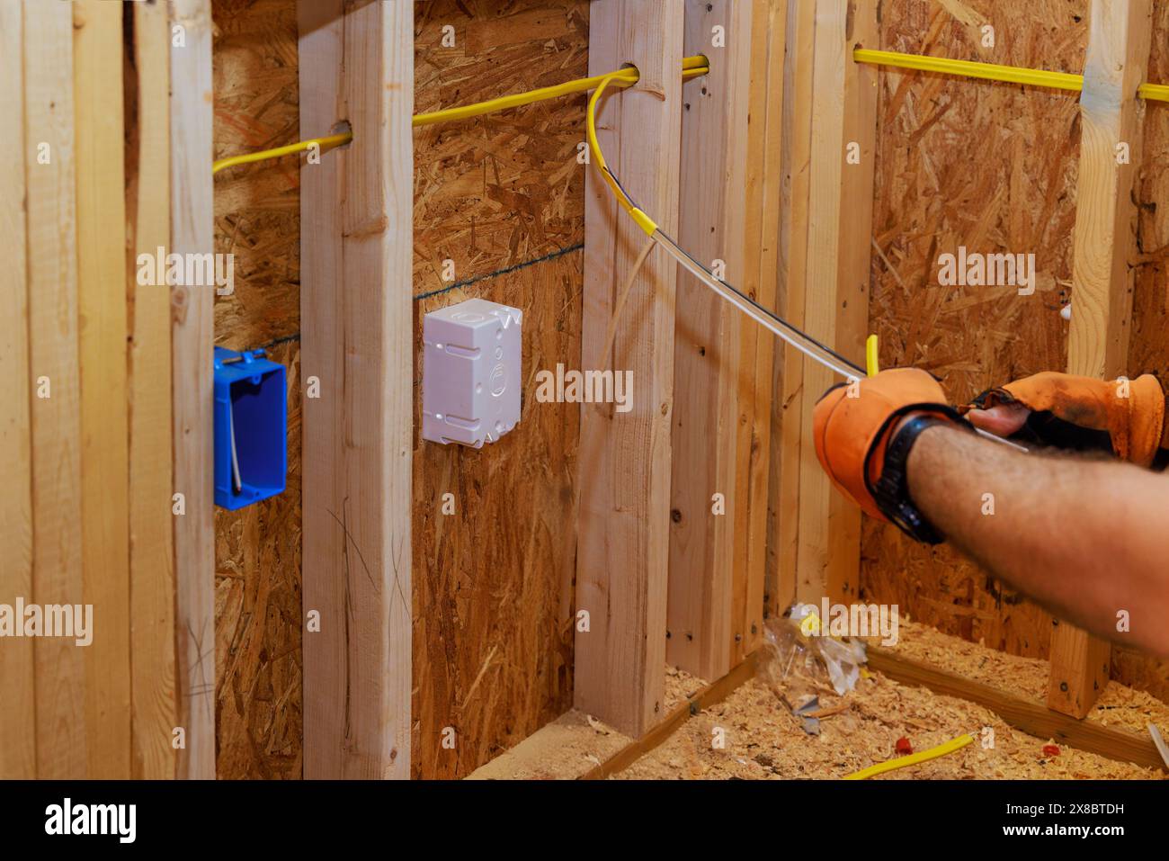 Les fils sont connectés aux boîtes à prises pendant la construction du nouveau bâtiment par un électricien Banque D'Images