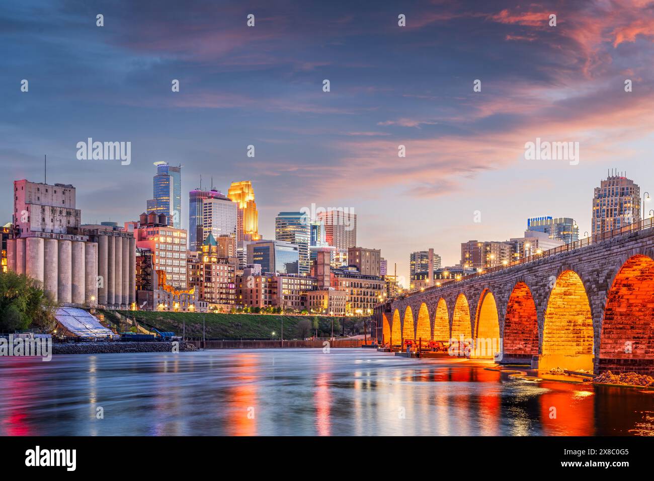 Minneapolis, Minnesota, USA skyline avec le pont Stone Arch sur le fleuve Mississippi au crépuscule. Banque D'Images