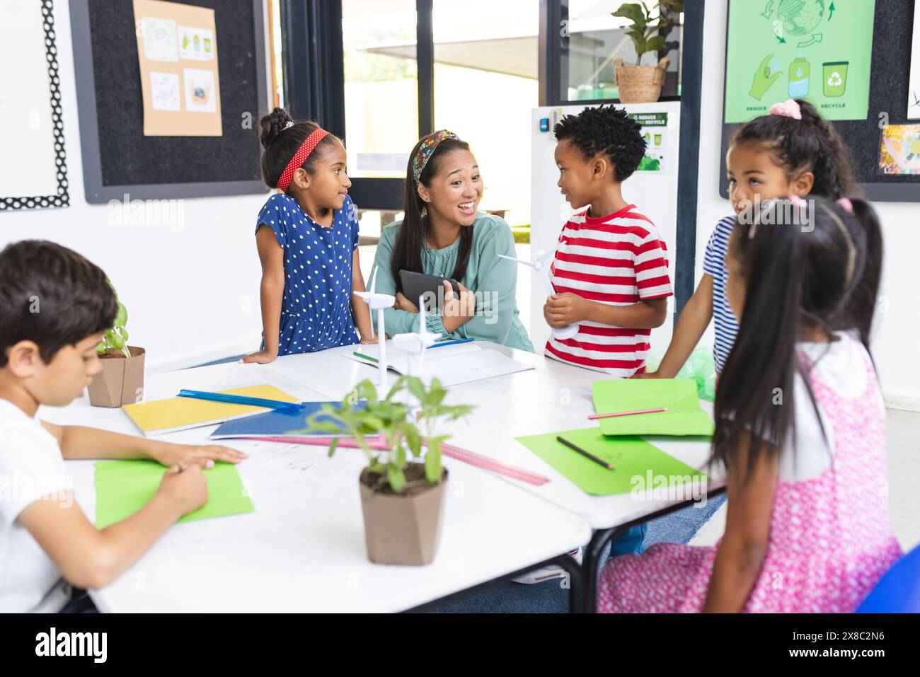 À l'école, femme asiatique d'âge moyen enseignant la durabilité à divers enfants en classe Banque D'Images