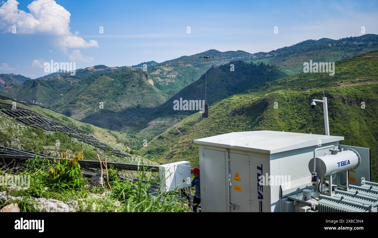 Guanling, province chinoise du Guizhou. 23 mai 2024. Un drone livre un panneau photovoltaïque sur le projet de base photovoltaïque de Panjiang d'un million de kilowatts dans le comté autonome de Bouyei-Miao de Guanling, dans la province du Guizhou, au sud-ouest de la Chine, le 23 mai 2024. La première phase du projet a récemment commencé à charger de l'électricité sur le réseau à pleine capacité. Crédit : Tao Liang/Xinhua/Alamy Live News Banque D'Images