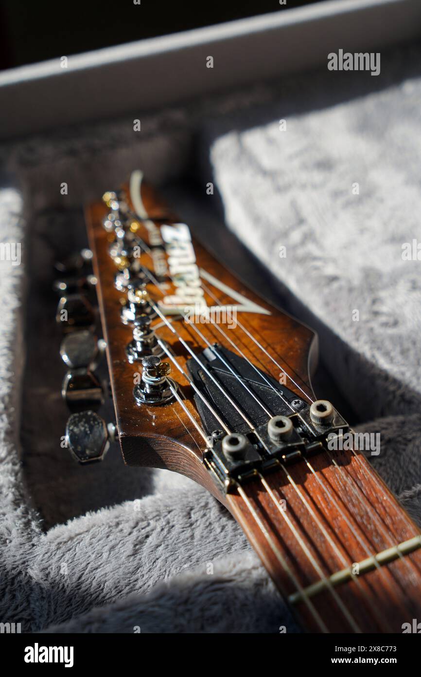 Gros plan d'ibanez cordes en acier guitare électrique tête et touche en bois de rose repose sur une garde en peluche, Istanbul Turquie 10 avril 2024 Banque D'Images