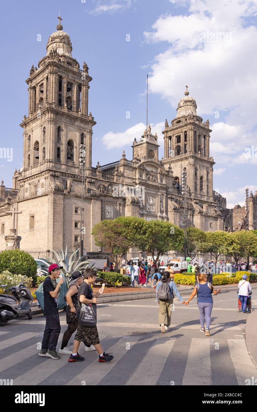 Population locale et touristes dans la rue devant la façade de la cathédrale de Mexico, Mexico, Mexique. Scène de rue de Mexico. Banque D'Images