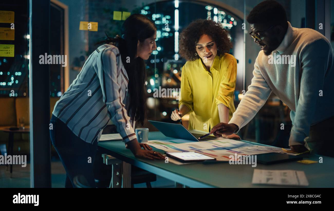 Développeur de logiciels excité dirigeant une réunion de bureau dans la salle de conférence de l'Agence créative dans la soirée. Équipe multiculturelle discutant d'un nouveau plan de projet avec les employés de l'entreprise. Banque D'Images