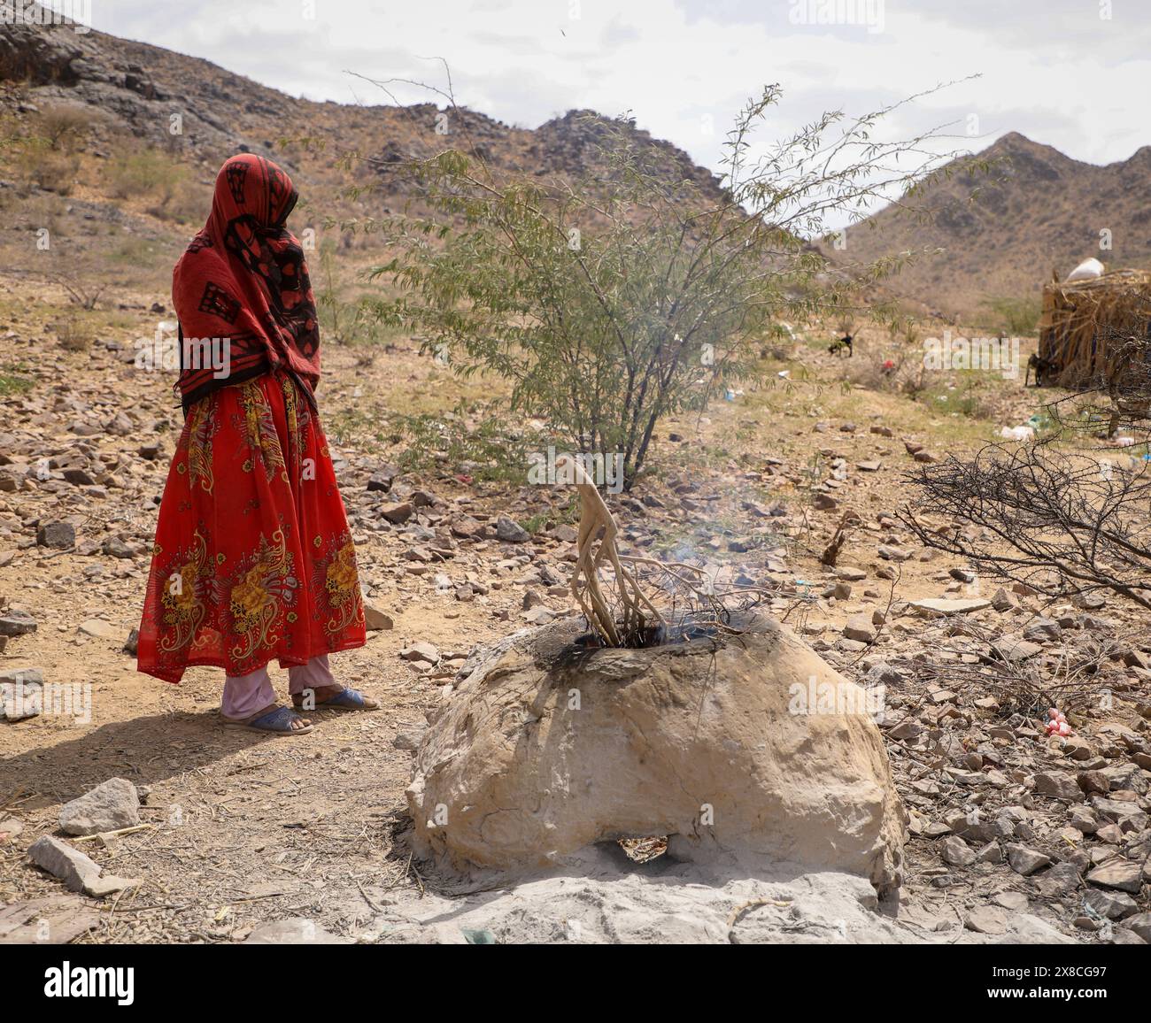 Taiz Yémen - 18 février 2022 : une femme yéménite fabrique de la nourriture pour ses enfants sans abri dans le camp de déplacement de la ville de Taiz Banque D'Images