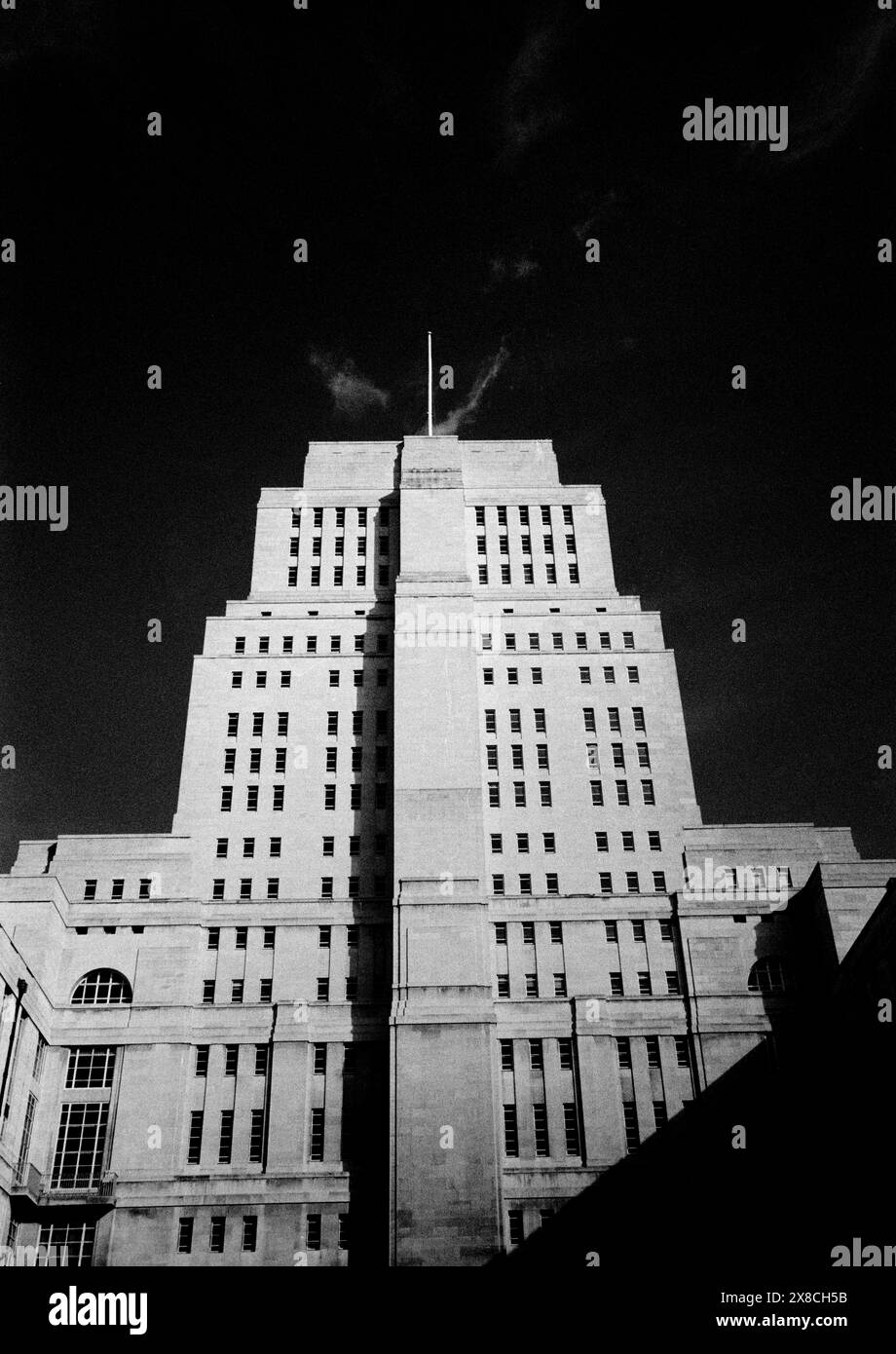 Senator House University of London , Londres England Senator House est le centre administratif de l'Université de Londres, situé au cœur de Bloomsbury, à Londres, immédiatement au nord du British Museum. Le bâtiment Art Déco a été construit entre 1932 et 1937 comme la première phase d'un vaste projet inachevé conçu pour l'université par Charles Holden. Il se compose de 19 étages et mesure 210 pieds (64 m) de haut. Pendant la seconde Guerre mondiale, l'utilisation du bâtiment par le ministère de l'information a inspiré deux œuvres de fiction d'écrivains anglais. Le plus ancien, le roman de Graham Greene The Mini Banque D'Images