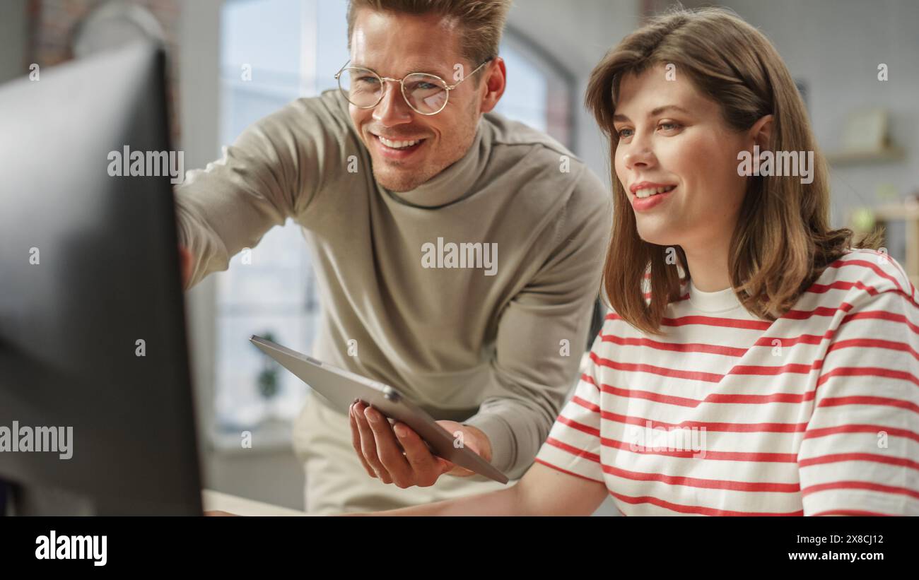 Portrait de deux collègues créatifs souriants et discutant de leur travail à l'aide d'un ordinateur et d'une tablette. White Male Brand Manager Consulting jeune femme Caucasien Directeur créatif. Gros plan. Banque D'Images