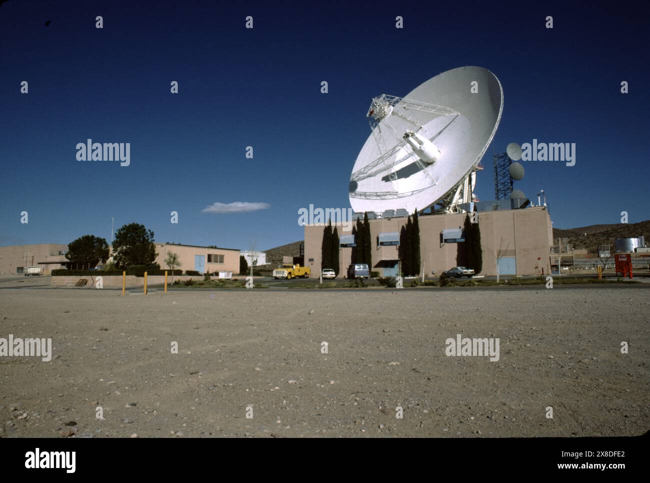 Fort Irwin, CA., États-Unis vers 1984. Le Goldstone Deep Space Communications Complex (GDSCC), communément appelé l'Observatoire Goldstone, situé à Fort Irwin dans l'État américain de Californie. Exploité par le Jet propulsion Laboratory (JPL) de la NASA, pour suivre et communiquer avec les missions spatiales interplanétaires. Il est nommé d'après Goldstone, en Californie, une ville fantôme minière d'or à proximité. La plus grande, une antenne Cassegrain de 70 mètres (230 pieds), est utilisée pour la communication avec les missions spatiales vers les planètes extérieures, comme le vaisseau spatial Voyager. Banque D'Images