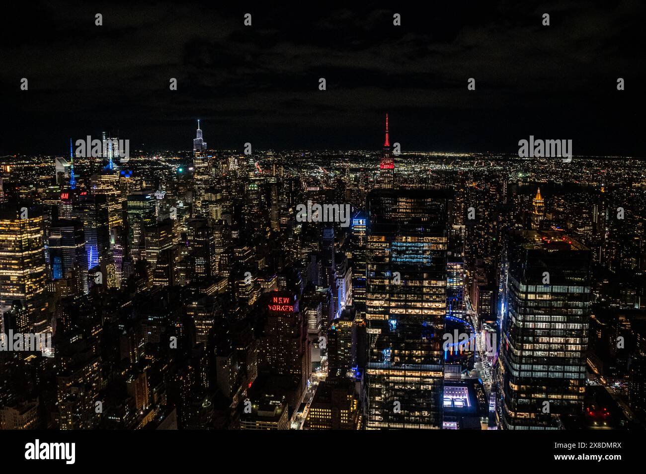 Horizon nocturne de Manhattan depuis une perspective audacieuse vue d'en haut. Des géants imposants traversent les nuages, offrant un point de vue unique pour voyager. Banque D'Images