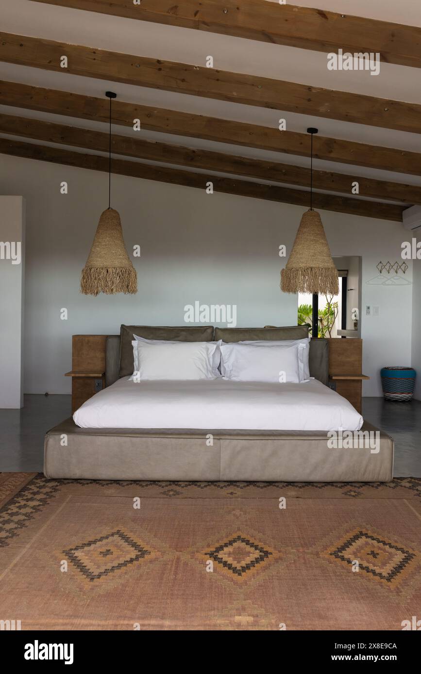 A la maison, grand lit dominant la pièce, poutres en bois supportant le plafond Banque D'Images