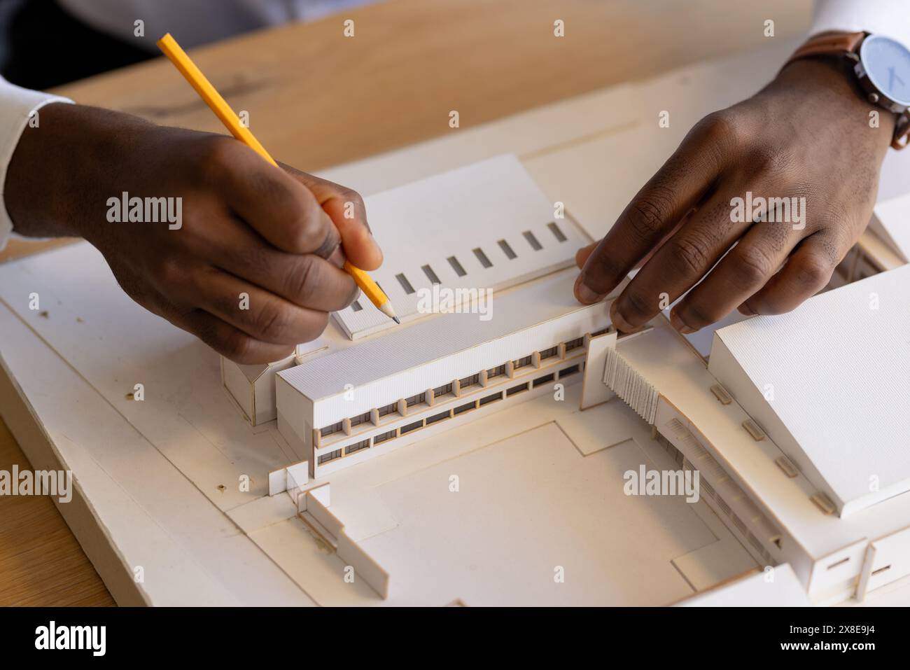 Jeune homme afro-américain travaillant sur un modèle architectural au crayon Banque D'Images