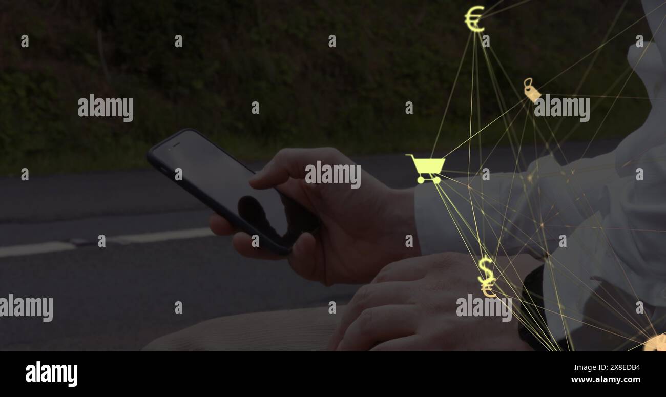 Homme caucasien tenant smartphone, assis par la route Banque D'Images