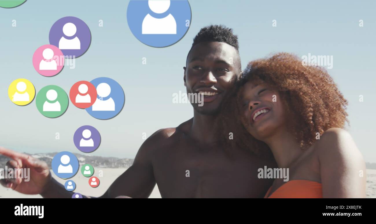 Image d'icônes de profil multicolores, couple diversifié assis et se relaxant à la plage contre le ciel Banque D'Images