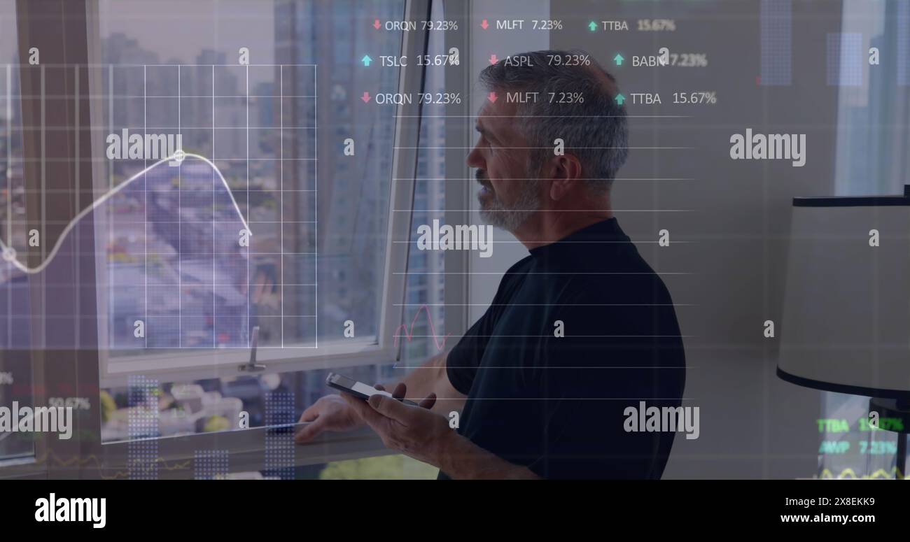 Image de graphiques, tableaux de négociation, homme caucasien senior debout près de la fenêtre et à l'aide d'un smartphone Banque D'Images