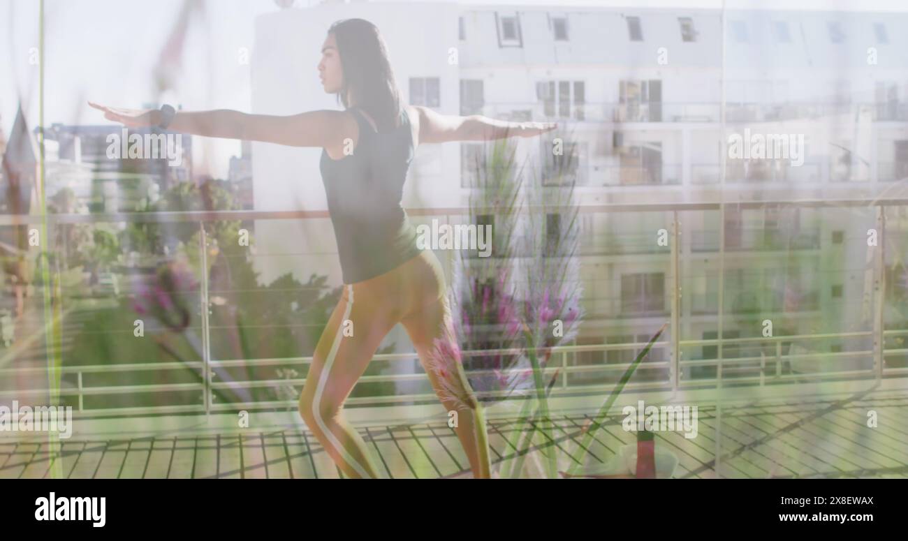 Image de plantes sur femme biraciale pratiquant le yoga Banque D'Images