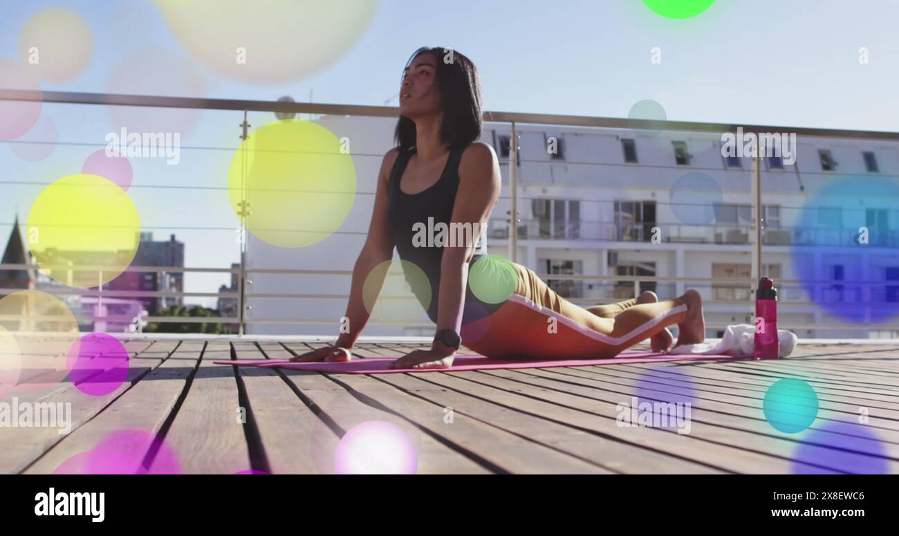 Image de lumières brillantes sur une femme biraciale pratiquant le yoga Banque D'Images