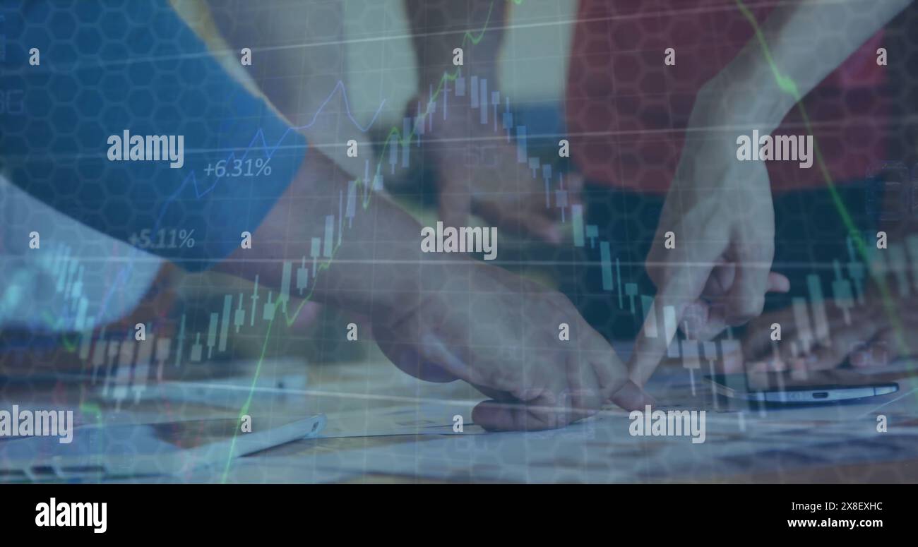 Image de graphiques se déplaçant sur diverses mains de gens d'affaires pointant vers le rapport sur le bureau Banque D'Images