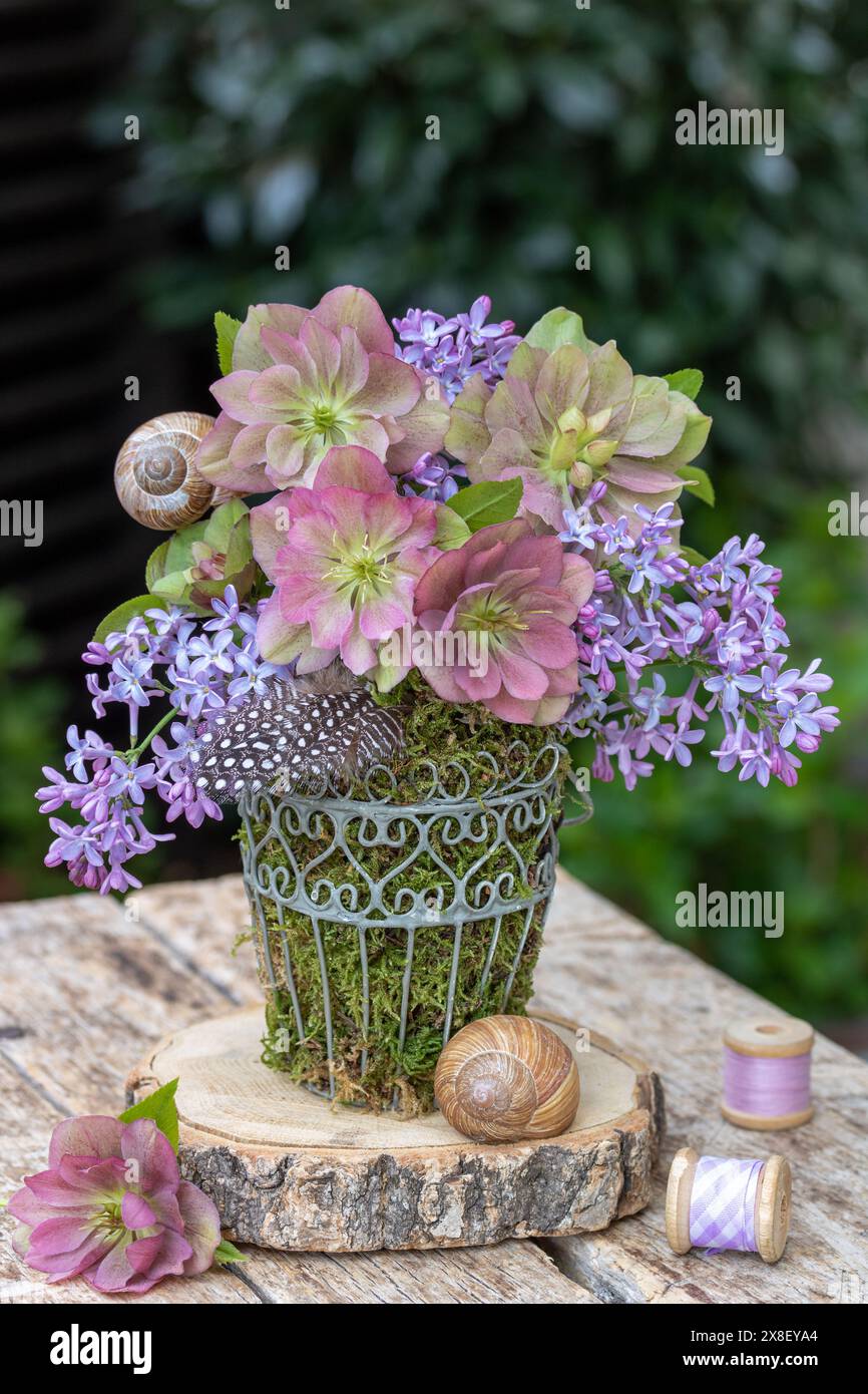 arrangement floral avec fleurs roses helleborus orientalis et lilas Banque D'Images