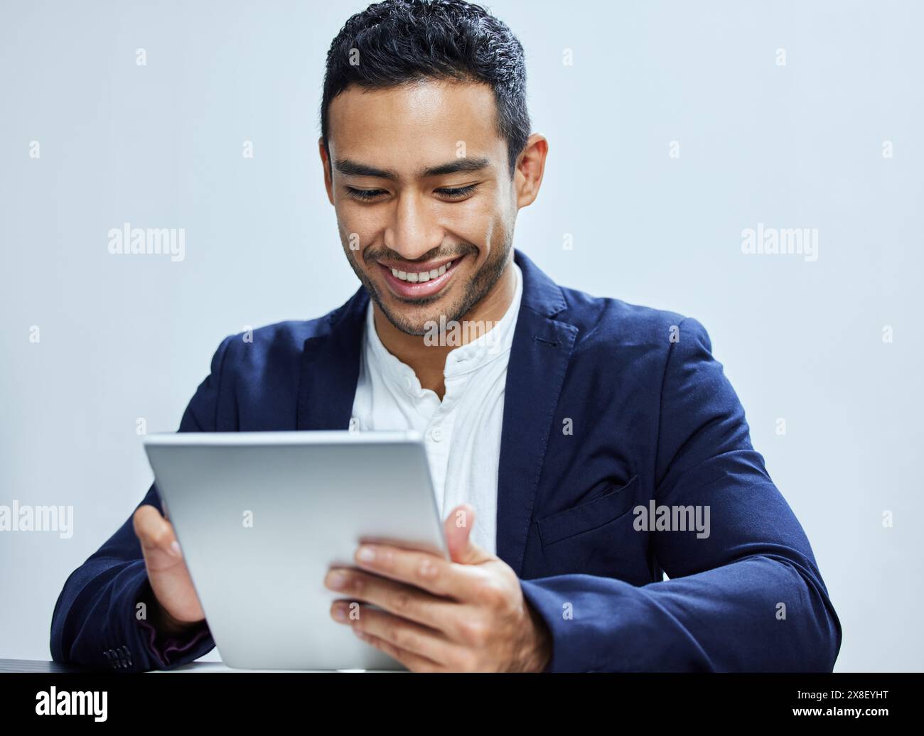 Tablette, sourire et homme d'affaires pour le défilement, l'écran tactile et l'agenda sur fond blanc. Personne responsable de la technologie, de l'entreprise et des finances, en ligne Banque D'Images