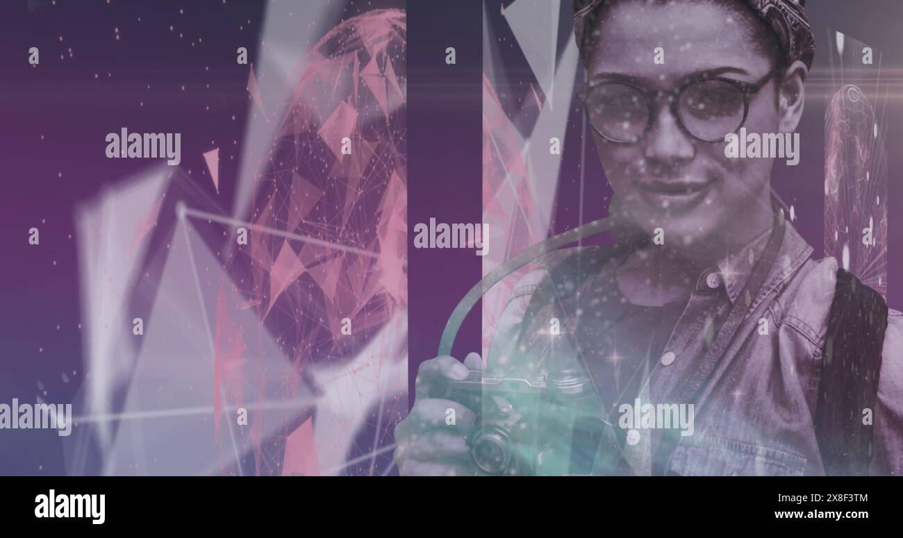 Jeune femme biraciale tenant la caméra, debout sur fond abstrait Banque D'Images