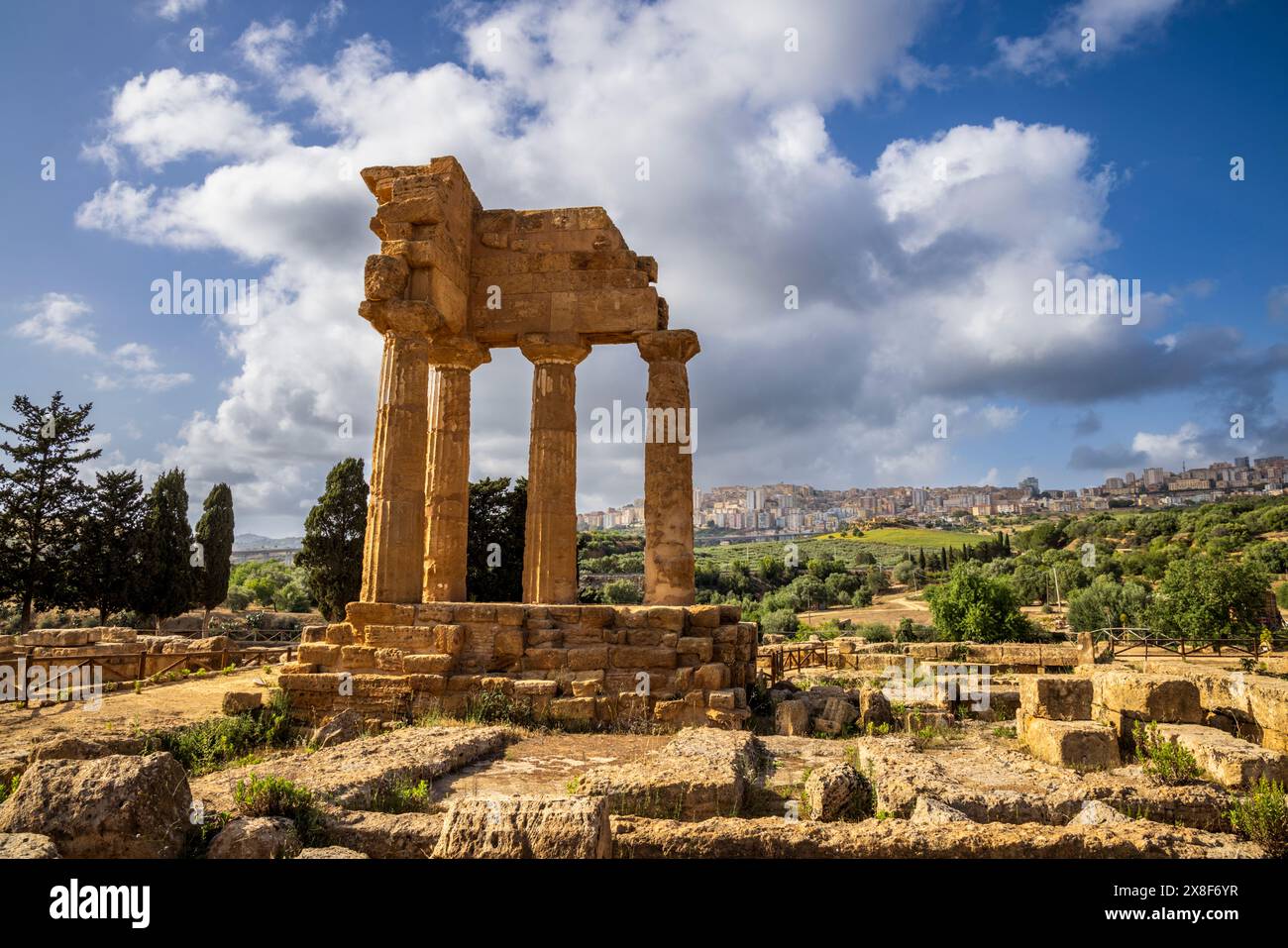 Le temple grec de Castor et Pollux avec Agrigente en arrière-plan, Vallée des temples, Agrigente, Sicile Banque D'Images