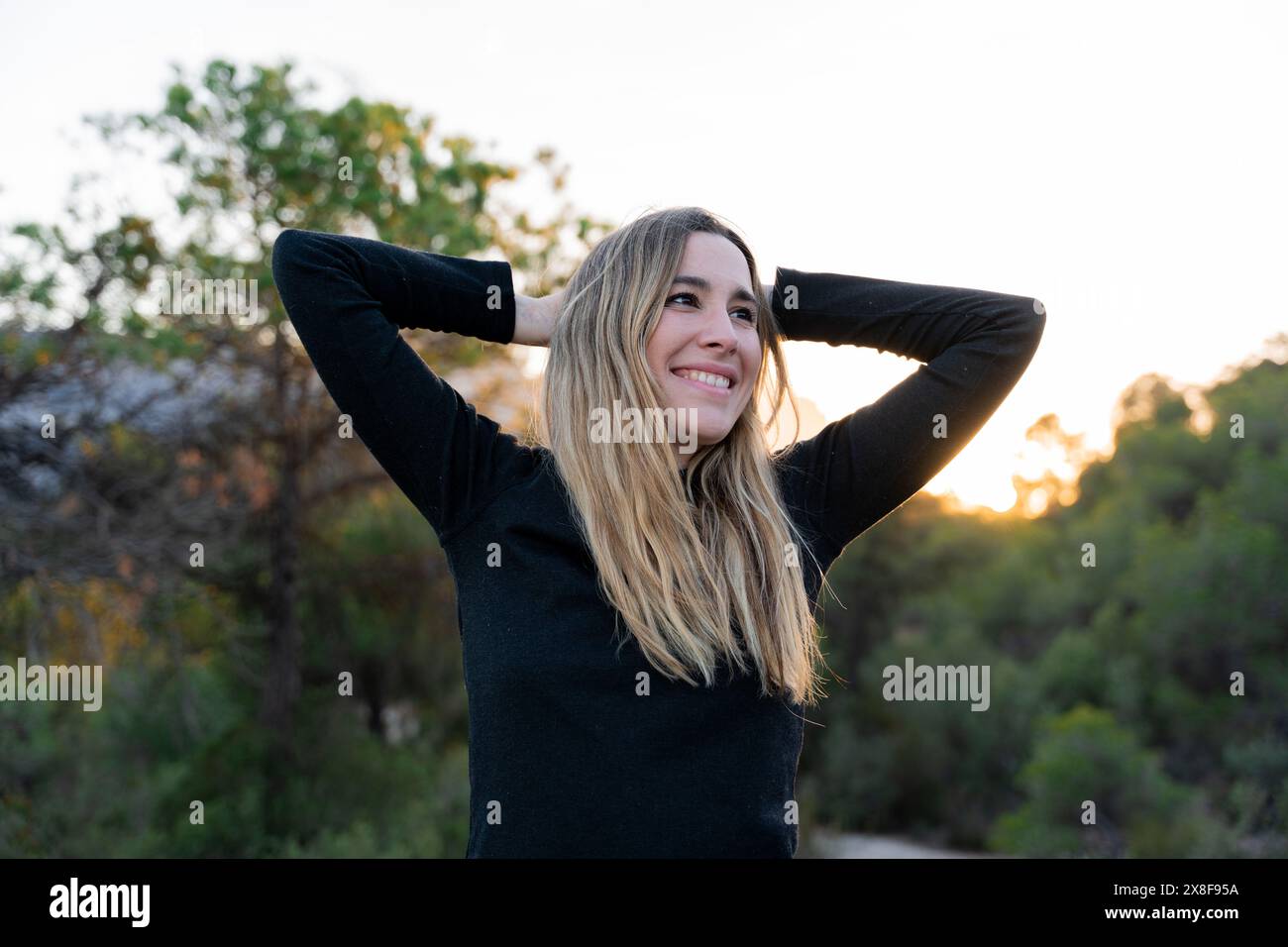 Femme souriante au contact de la nature. Paix intérieure et bien-être émotionnel Banque D'Images