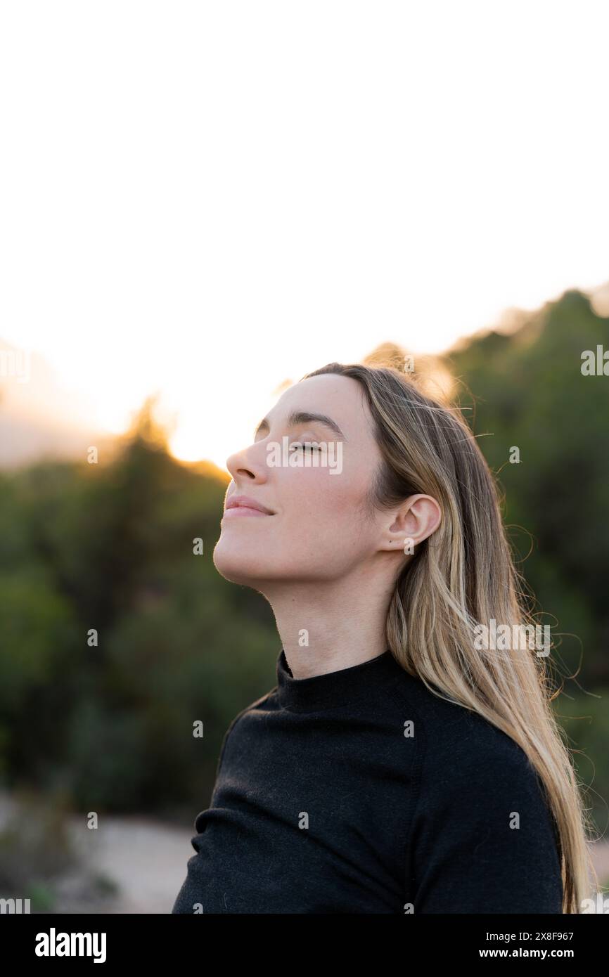 Portrait vertical d'une femme respirant de l'air frais. Paix intérieure Banque D'Images