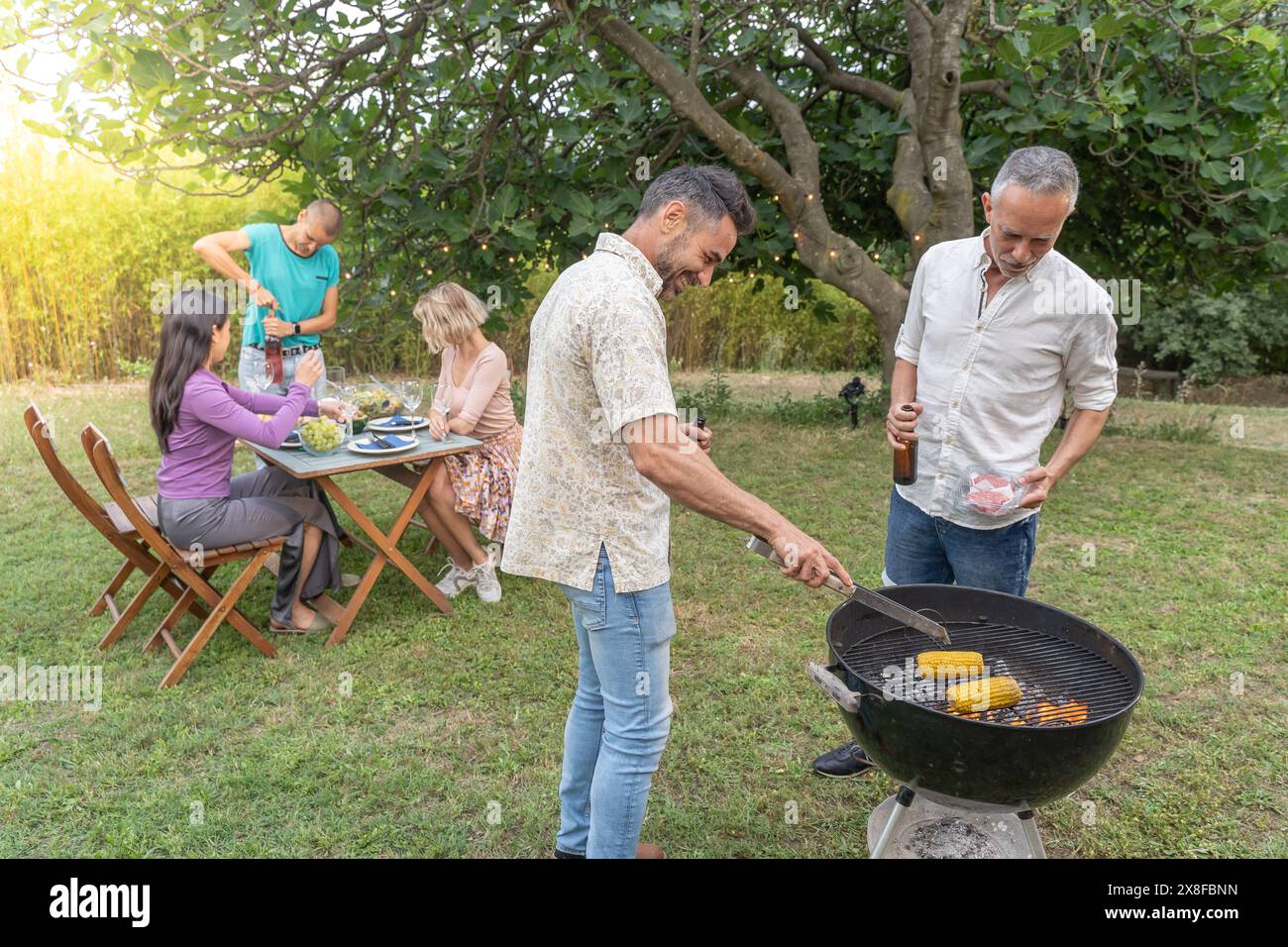 Famille autour du barbecue ensemble. Banque D'Images