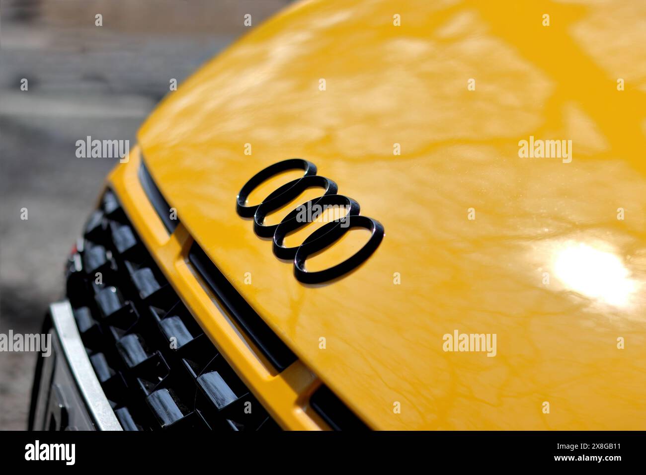 Un logo d'Audi sur une partie avant d'une voiture jaune Banque D'Images