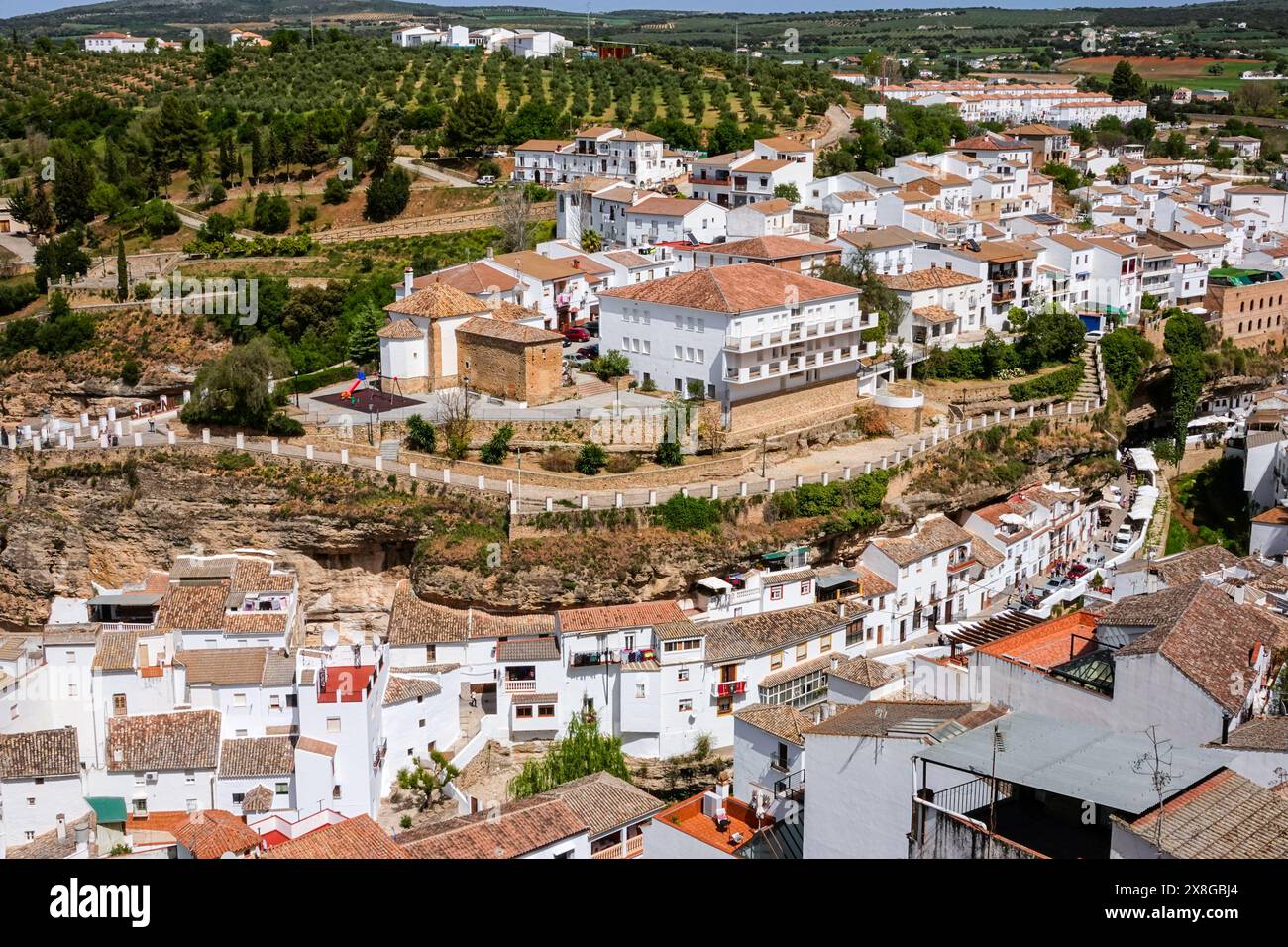 Vue panoramique montrant le Rio Trejo et l'église Ermita de Nuestra Señora del Carmen dans l'unique pueblos blanco de Setenil de las Bodegas, Espagne. Les habitants du petit village de Setenil vivent dans des maisons de grottes depuis l'époque néolithique. Banque D'Images