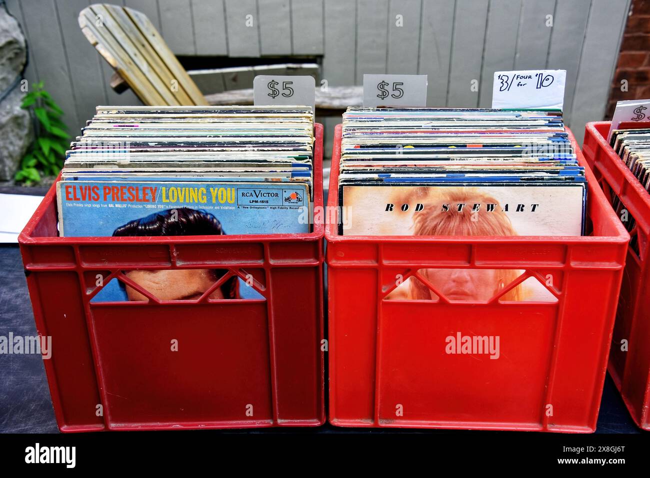 Ottawa, Canada - 25 mai 2024 : contenant de lait d'albums, dont Elvis Presley et Rod Stewart, en vente lors de la vente annuelle de garage de quartier Glebe, qui a lieu à plusieurs pâtés de maisons dans le quartier Glebe d'Ottawa, Ontario. Les cartons de lait étaient des méthodes populaires de stockage des albums. Banque D'Images