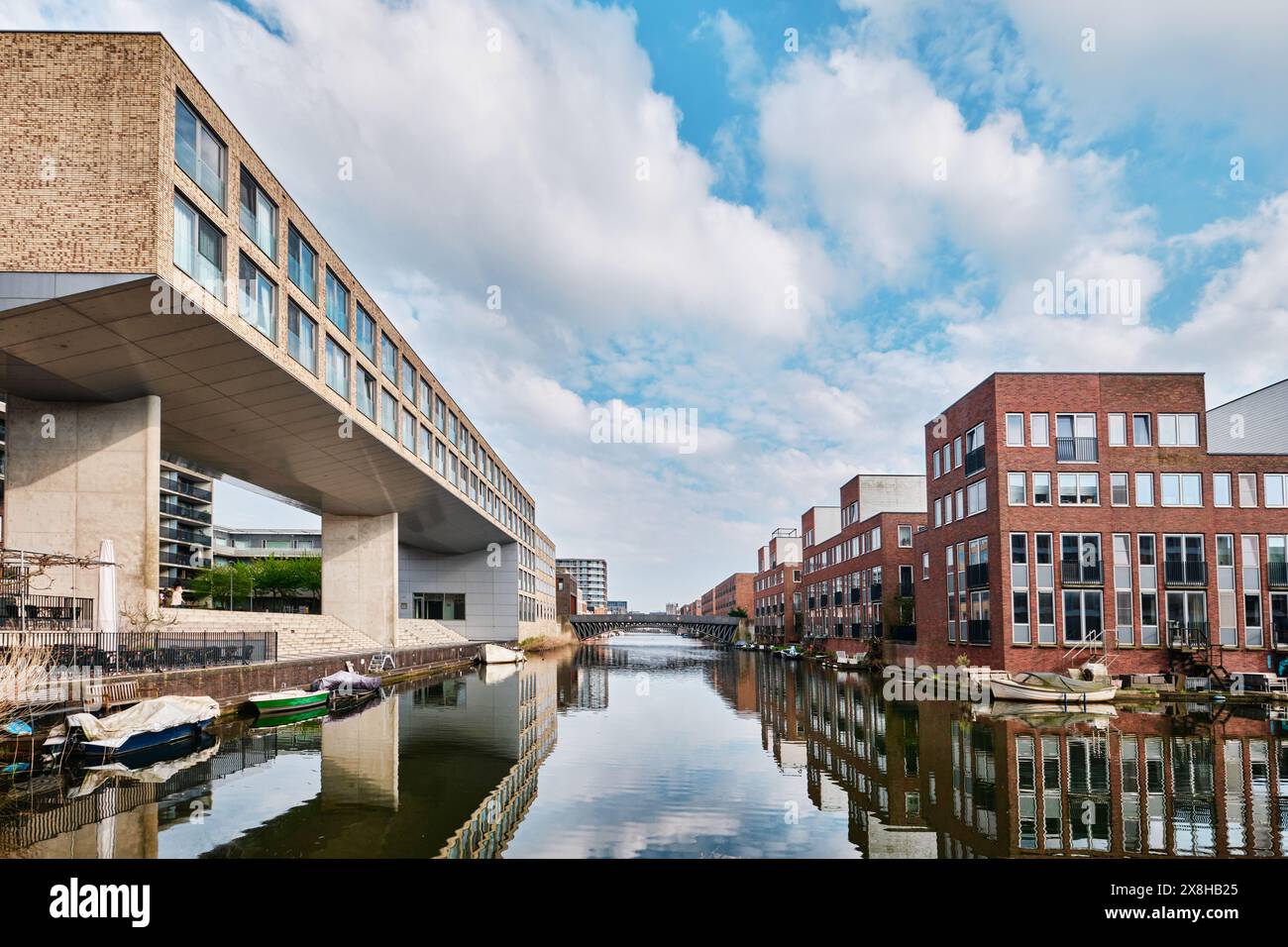 Pays-Bas, Amsterdam - 10 avril 2024 : bâtiments résidentiels et architecture moderne en briques avec vue sur le canal dans le district d'Ijburg Banque D'Images