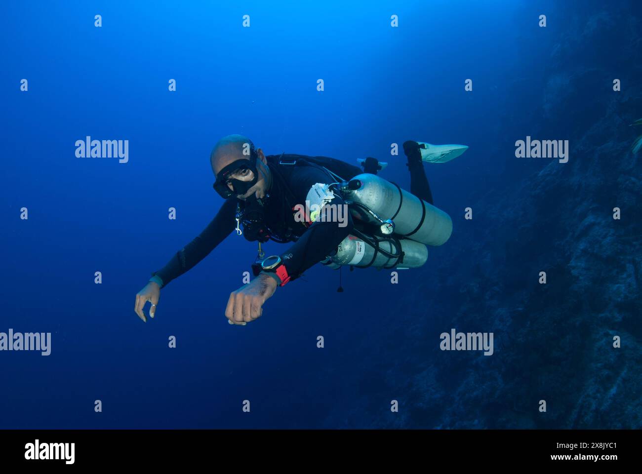 Un plongeur sidemount avec une coupe parfaite dans l'eau bleue des Caraïbes. Le plongeur est équipé de matériel, de gaz et de formation à la plongée technique Banque D'Images