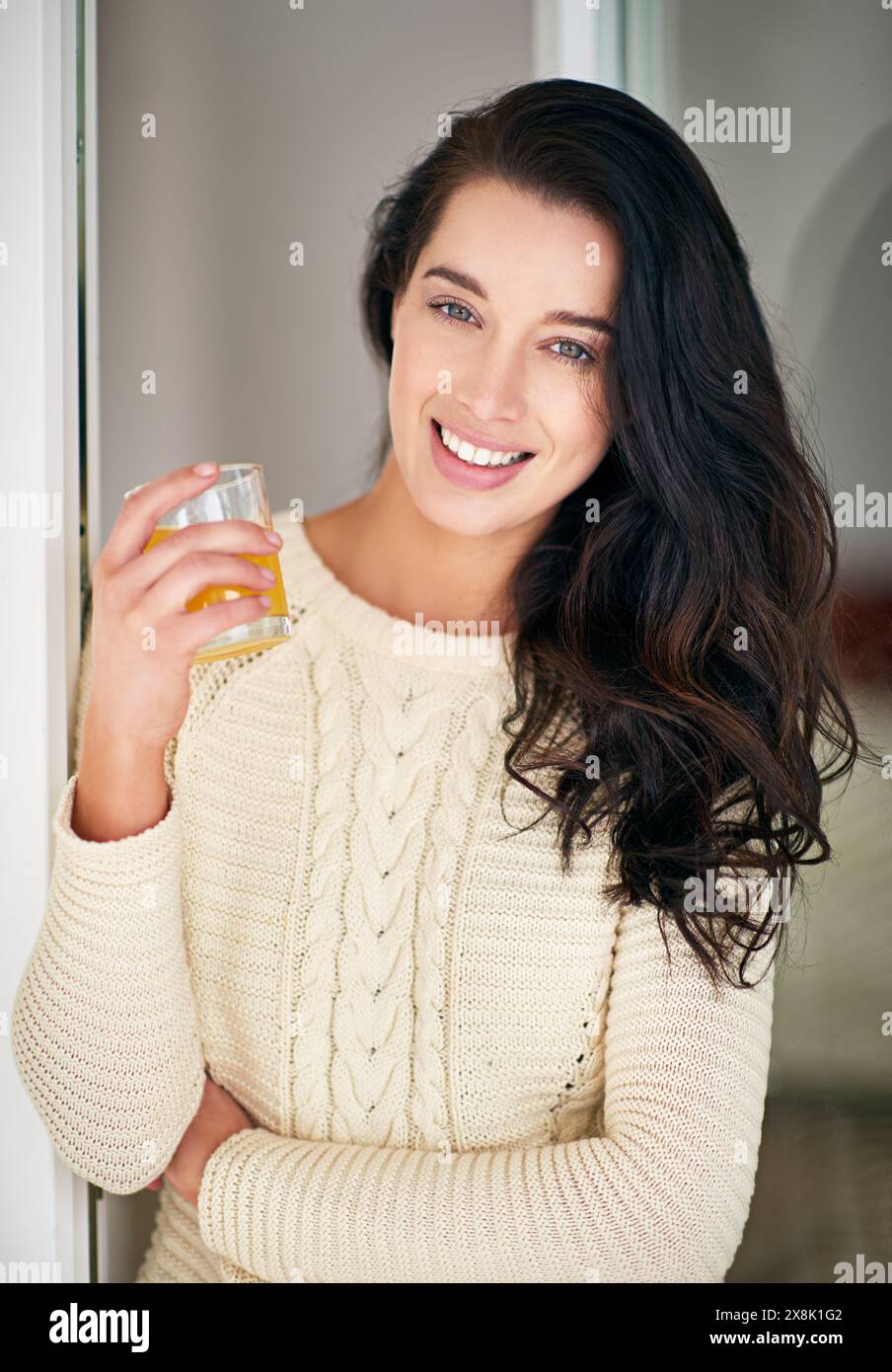 Relax, femme et portrait boire du jus à la maison pour le petit déjeuner, une alimentation saine et une nutrition avec bonheur. Sourire, personne féminine et boisson orange Banque D'Images