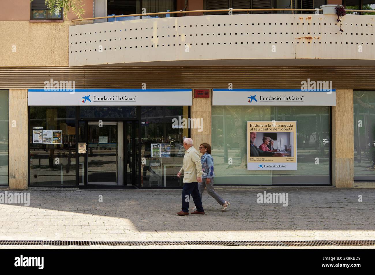 Viladecans, Barcelone, Espagne-26 mai 2024 : image de la façade d'un bureau de la Fondation la Caixa avec deux personnes marchant sur le trottoir. Banque D'Images