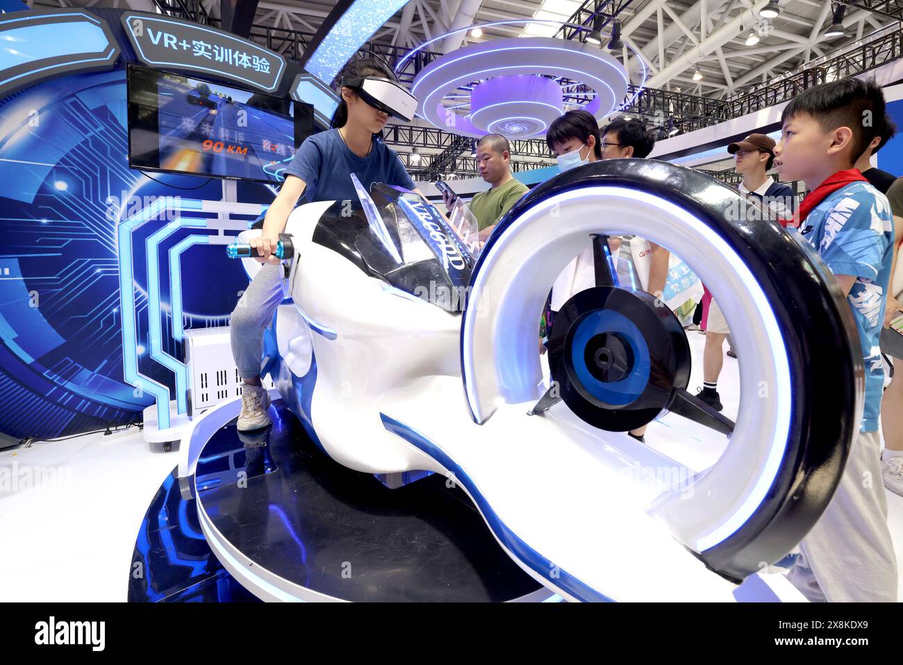 FUZHOU, CHINE - 26 MAI 2024 - les enfants font l'expérience du projet de course de moto Speed of Light Flywheel VR à la zone d'exposition Webdragon du 7t Banque D'Images
