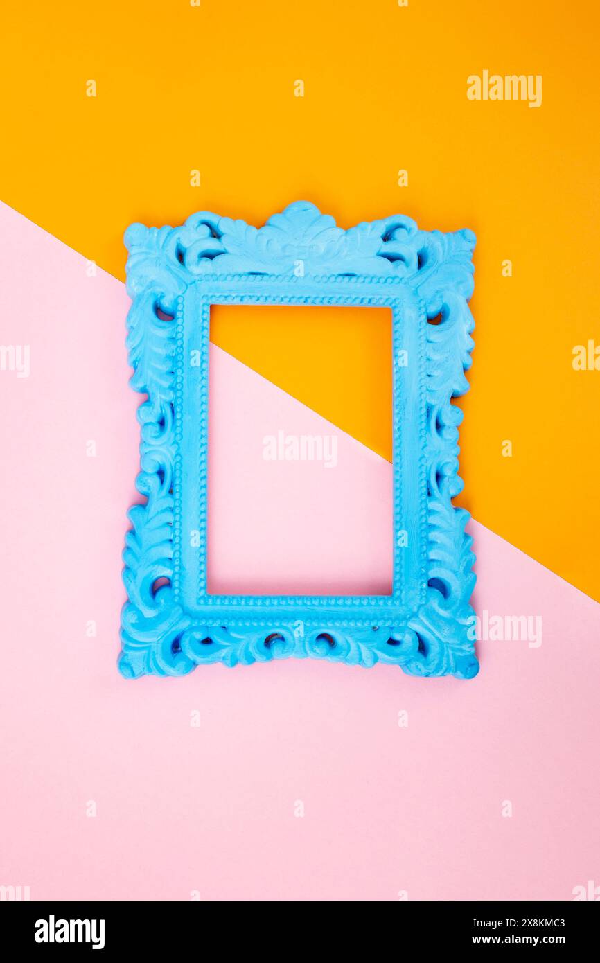 Cadre classique bleu sur fond de papier bicolore, orange et rose Banque D'Images