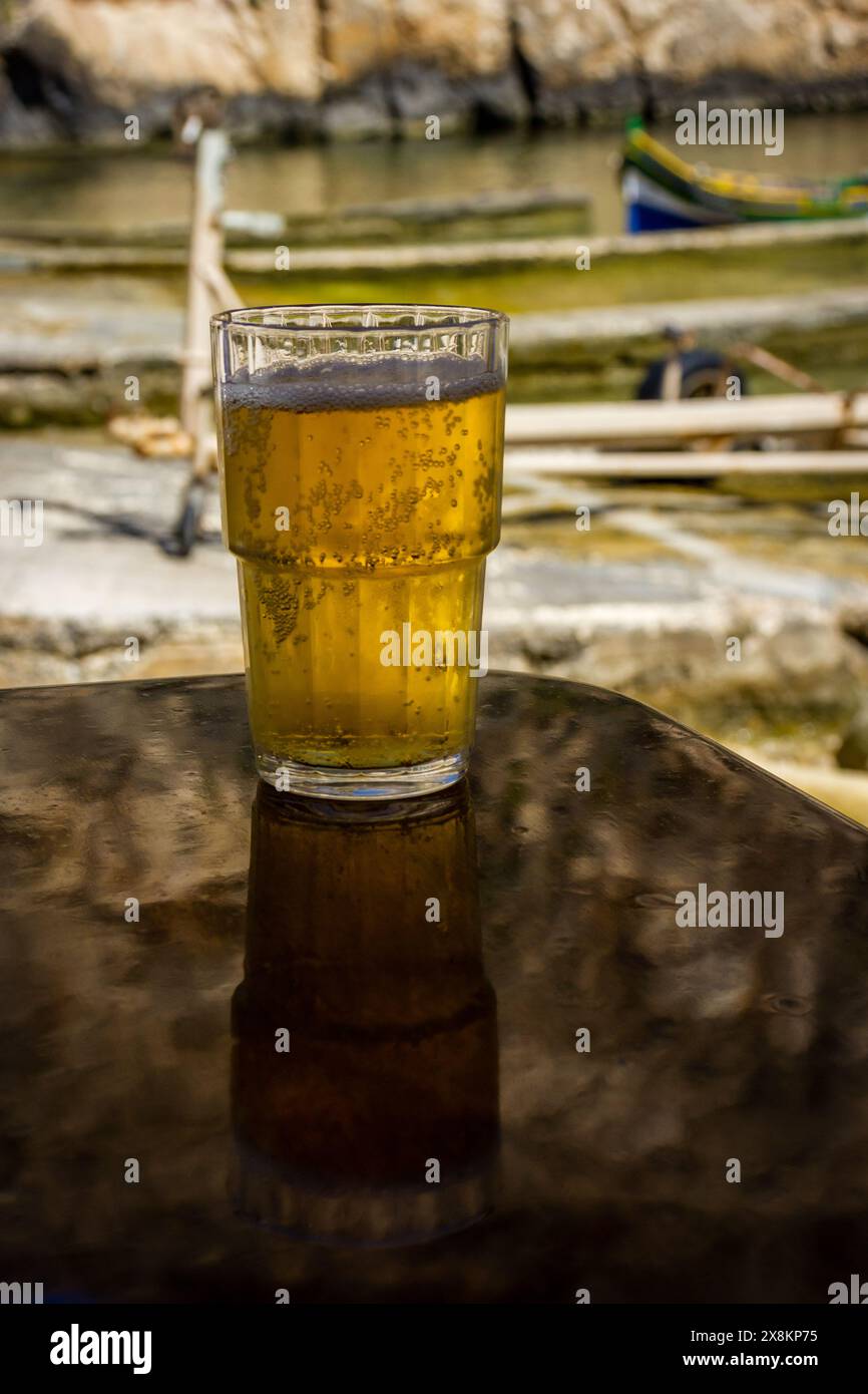Rafraîchissant lager en bord de mer sur une table, évoquant le parfait rafraîchissement estival. Banque D'Images