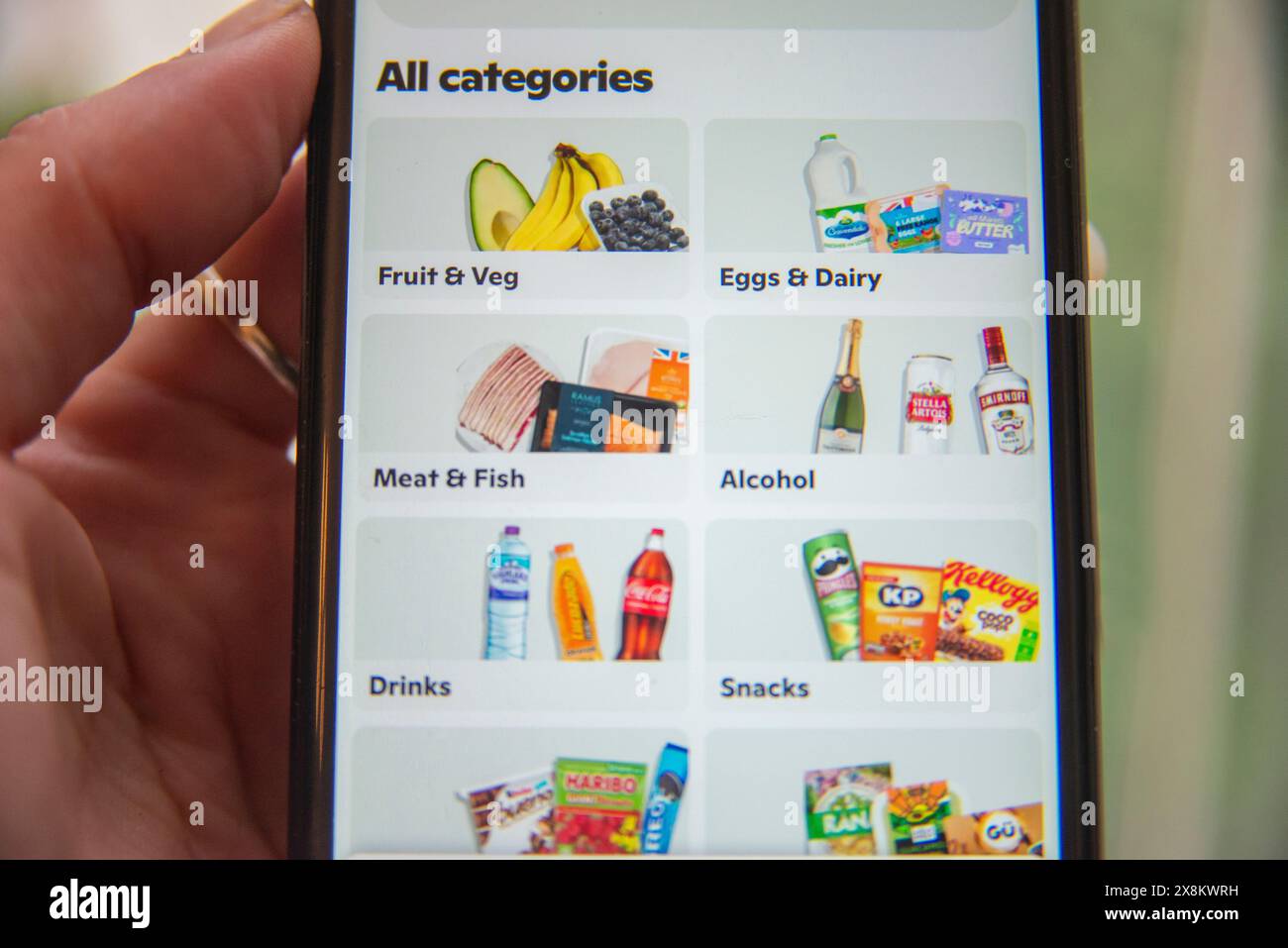 Smartphone affichant l'application GoPuff avec des catégories pour l'épicerie, y compris les fruits, les produits laitiers et les collations. Banque D'Images