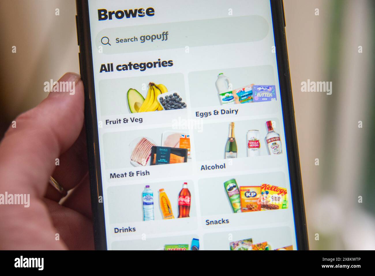 Smartphone affichant l'application GoPuff avec des catégories pour l'épicerie, y compris les fruits, les produits laitiers et les collations. Banque D'Images