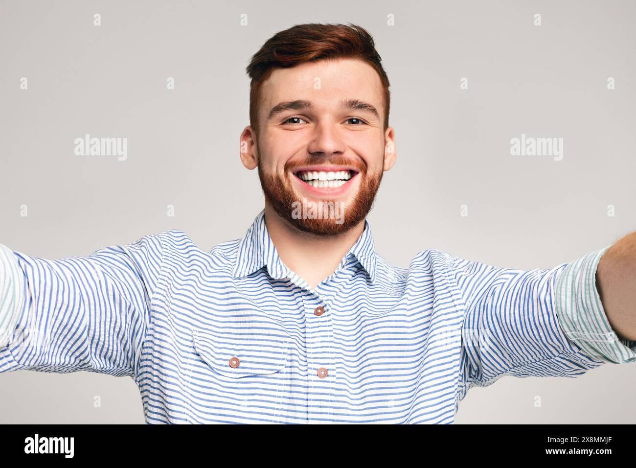 Beau jeune homme tenir l'appareil photo et faire selfies Banque D'Images