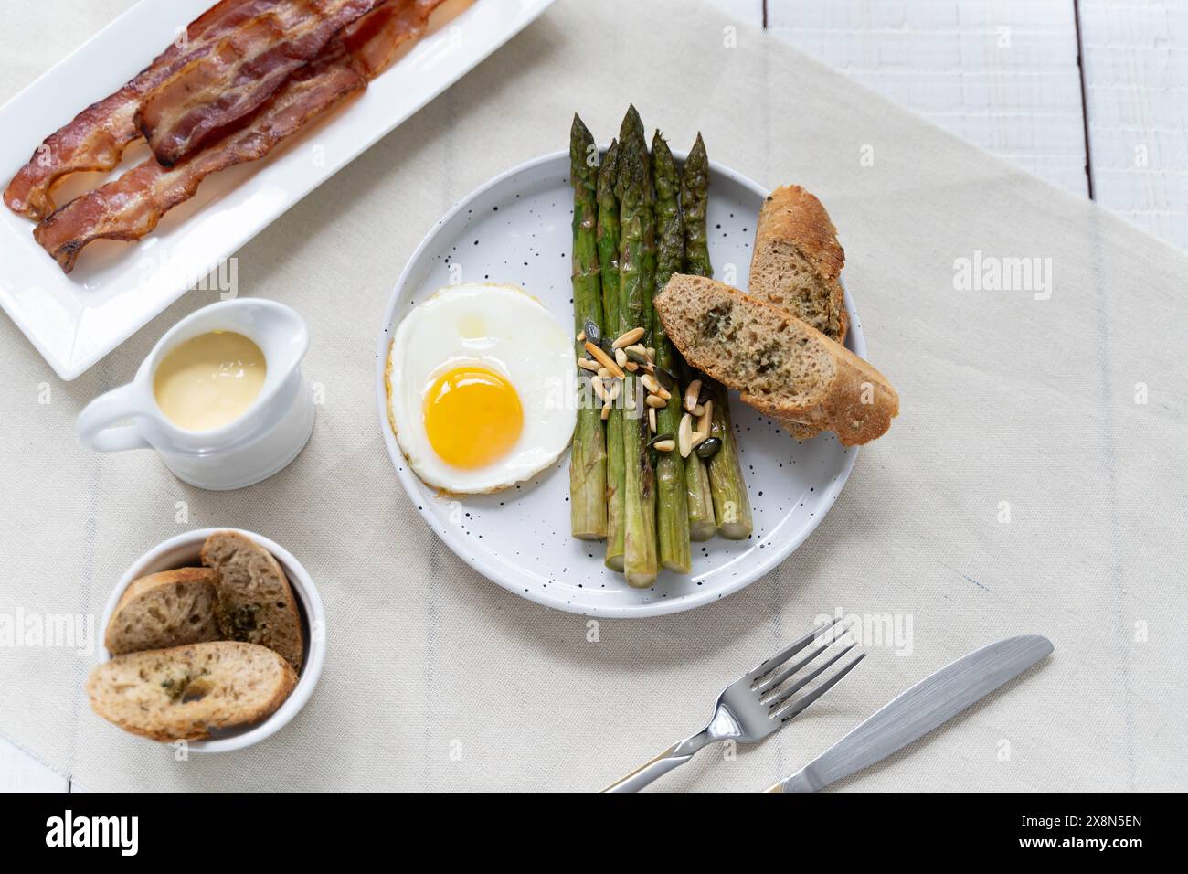 Asperges vertes servies avec œufs frits, bacon et pain à l'ail. Les asperges représentant les fibres alimentaires sont très populaires en Allemagne pendant Spargelzeit Banque D'Images