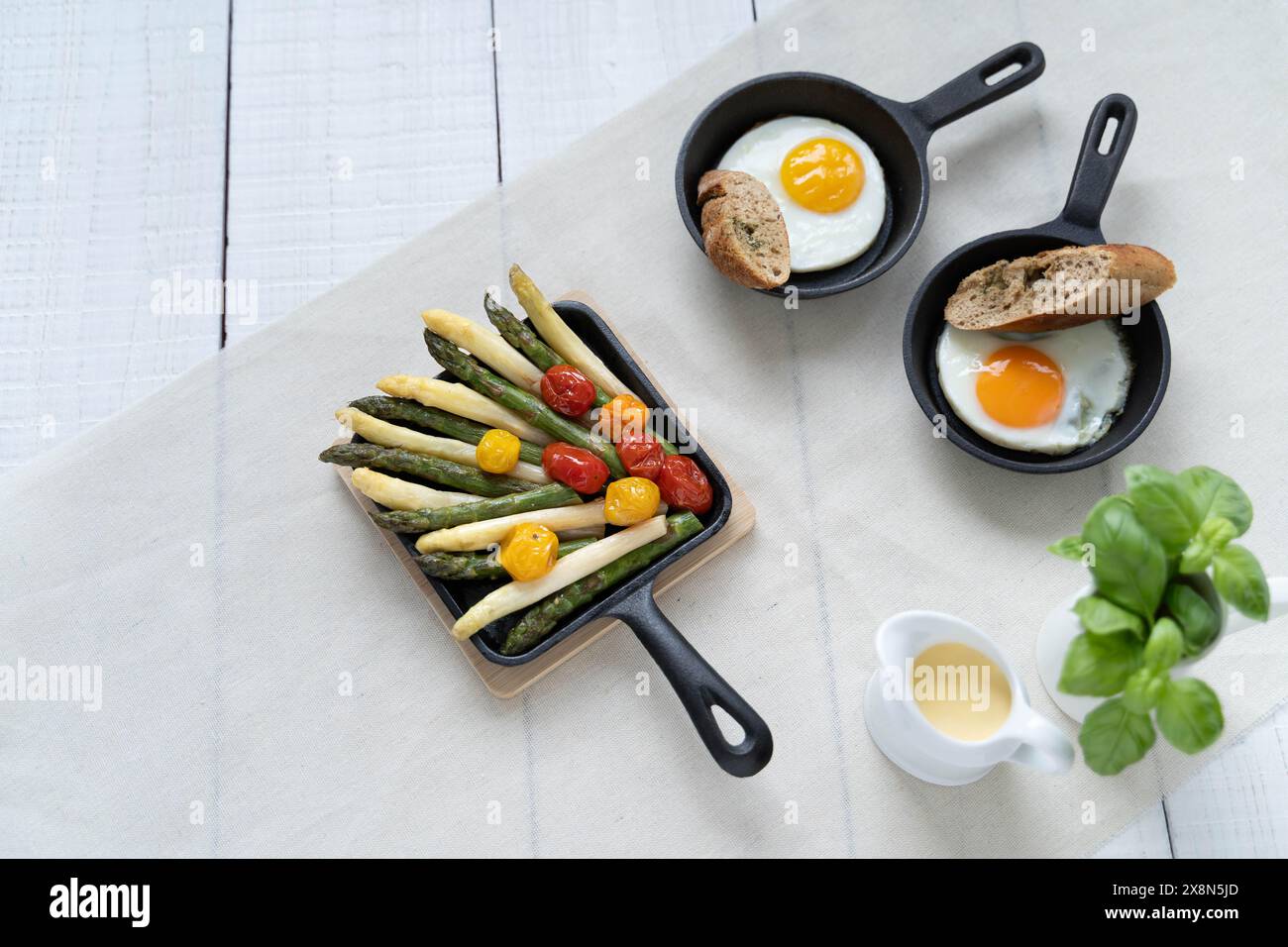 Asperges vertes et blanches servies avec tomates, œufs au plat, pommes de terre bouillies. Ce plat de saison est très populaire en Allemagne pendant le Spargelzeit Banque D'Images