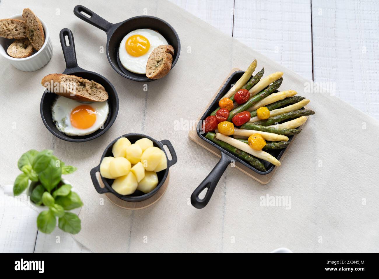 Asperges vertes et blanches servies avec tomates, œufs au plat, pommes de terre bouillies. Ce plat de saison est très populaire en Allemagne pendant le Spargelzeit Banque D'Images