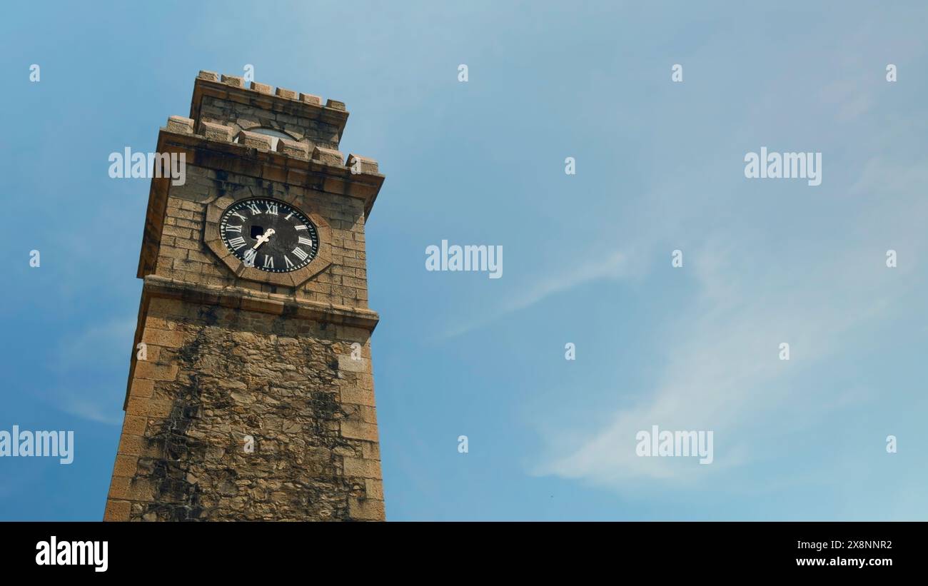 Tour d'horloge historique avec des nuages pittoresques et un ciel bleu sur le fond. Action. Vue en bas angle de l'ancienne tour de briques. Banque D'Images