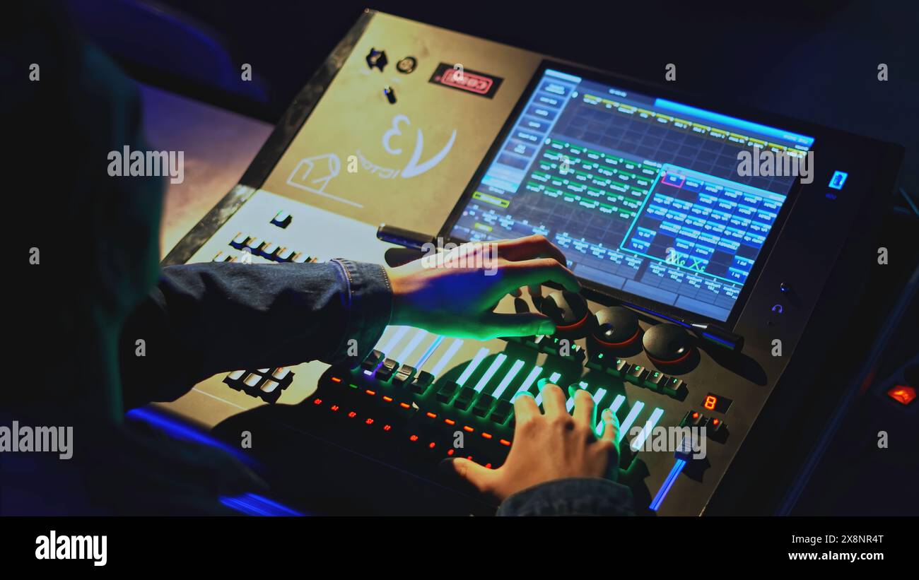 Commande de console d'éclairage. Support. L'homme déplace les joysticks sur le panneau de commande de lumière et de son dans le théâtre. Console de contrôle moderne du son et de la lumière dans le théâtre Banque D'Images