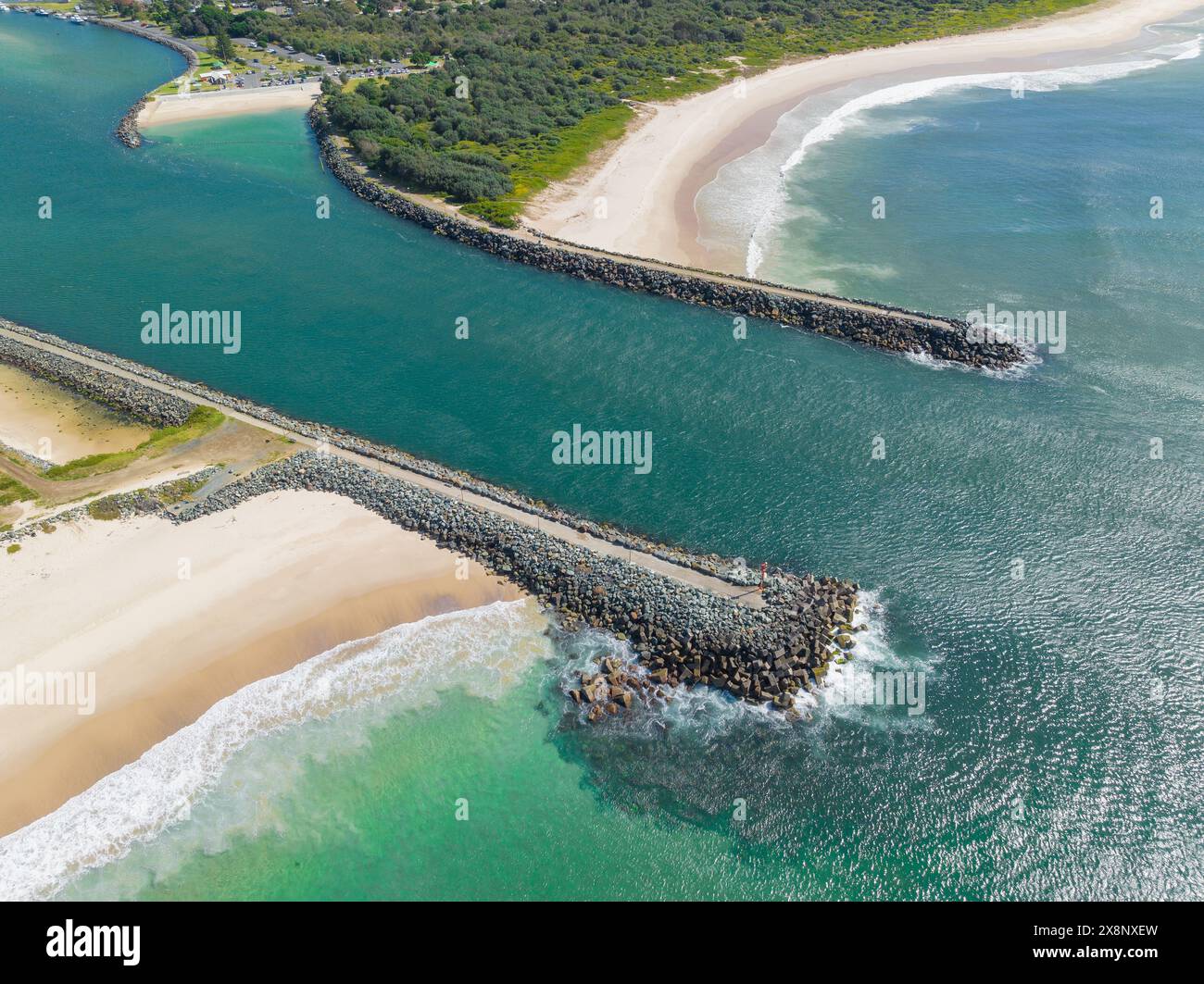 Vue aérienne d'une rivière qui coule en mer entre des brise-lames rocheux à Forster en Nouvelle-Galles du Sud, Australie Banque D'Images