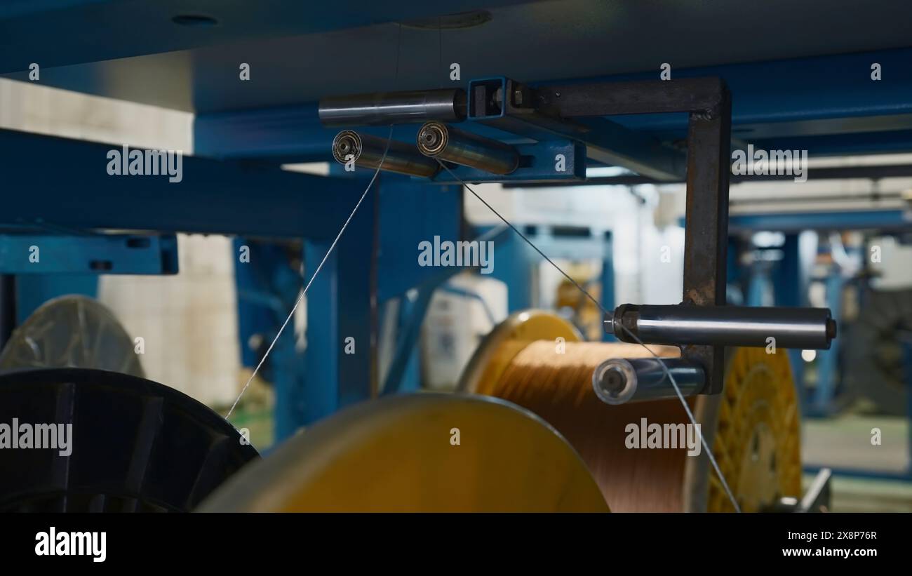 Bobines rotatives avec des fils en usine. Créatif. Distribution et bobinage de fils sur bobines à l'entreprise métallurgique. Enroulement de lignes polymères sur Banque D'Images