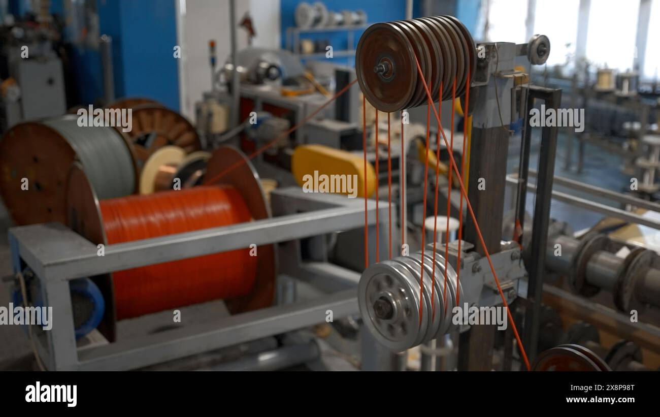 Machine industrielle tournante avec bobines et fils. Créatif. Atelier à l'usine industrielle avec des machines de filature. Banque D'Images