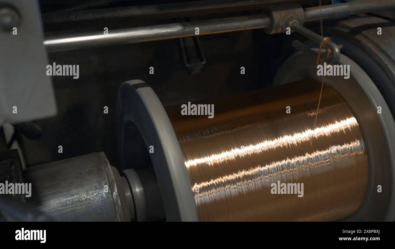 Bobines rotatives avec des fils métalliques à l'usine. Créatif. Enroulement de fibres métalliques sur bobines dans une installation métallurgique. Procédé de torsion en bobines de Banque D'Images