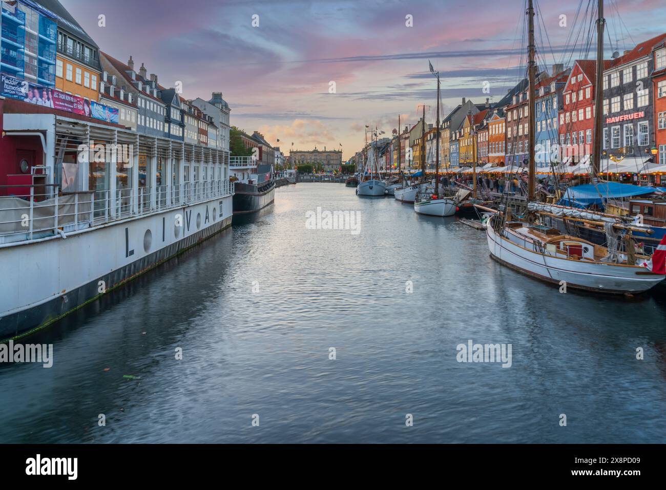 Découvrez l'atmosphère enchanteresse du canal Nyhavn de Copenhague avec cette image qui capture le front de mer historique et ses maisons de ville colorées Banque D'Images